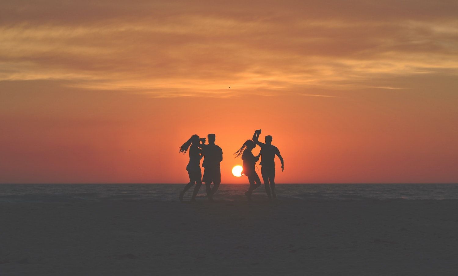 friends having fun on beach at sunset integrating ketamine treatments