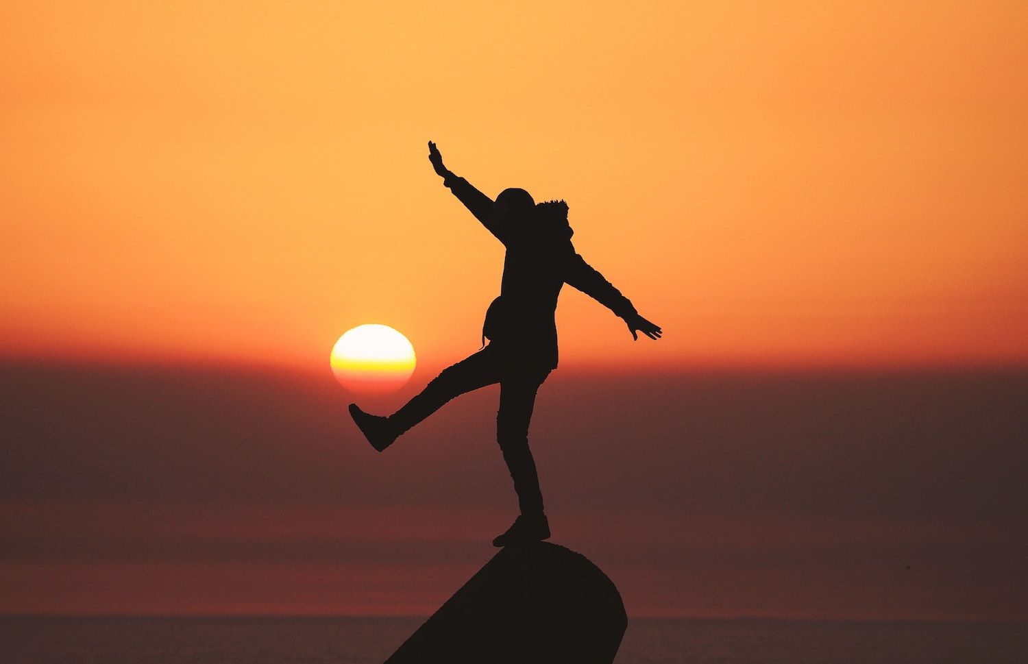 silhouette of person reaching their potential at sunset 