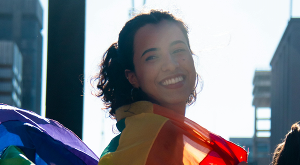 Girl smiling holding Gay Pride flag
